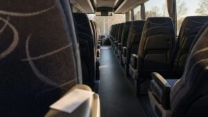 Interior de ônibus interestadual com bilhete de passagem sobre o braço da poltrona